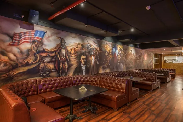 Booths under a large painted mural in the dining hall